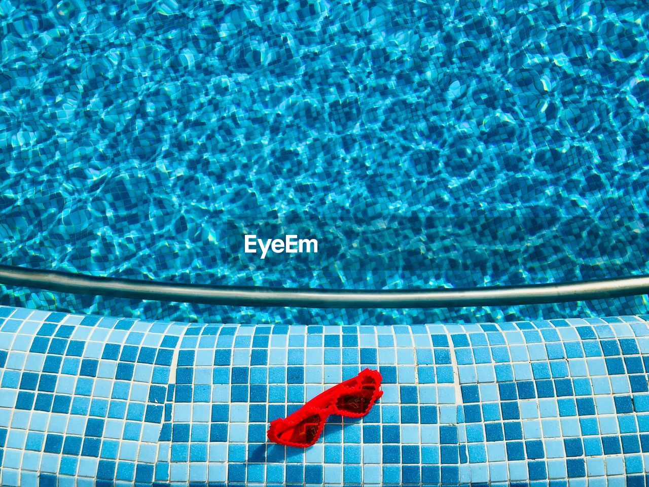 High angle view of red sunglasses at poolside