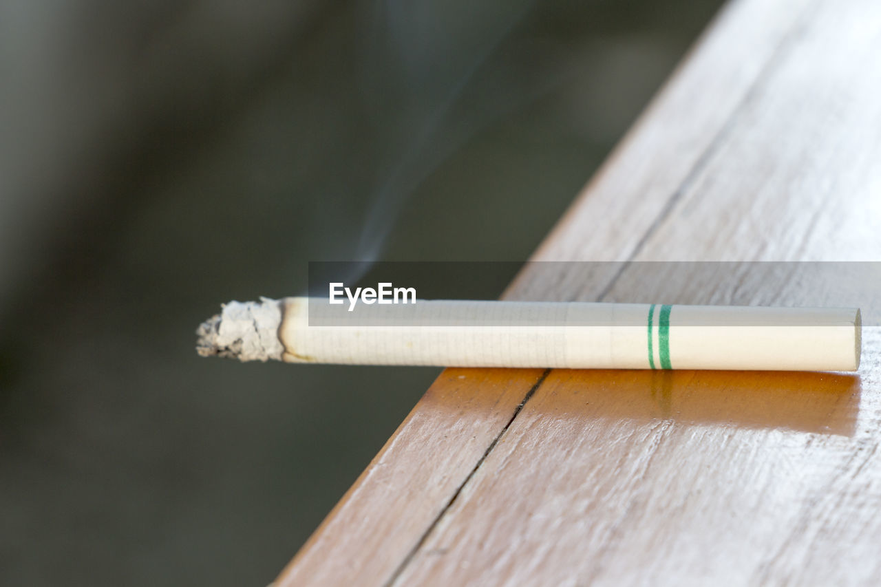 High angle view of burning cigarette on table