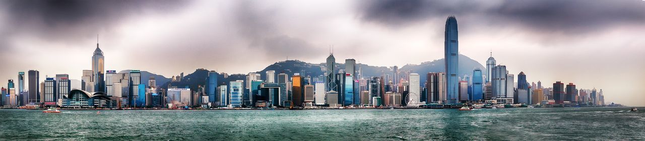 Buildings in city against cloudy sky