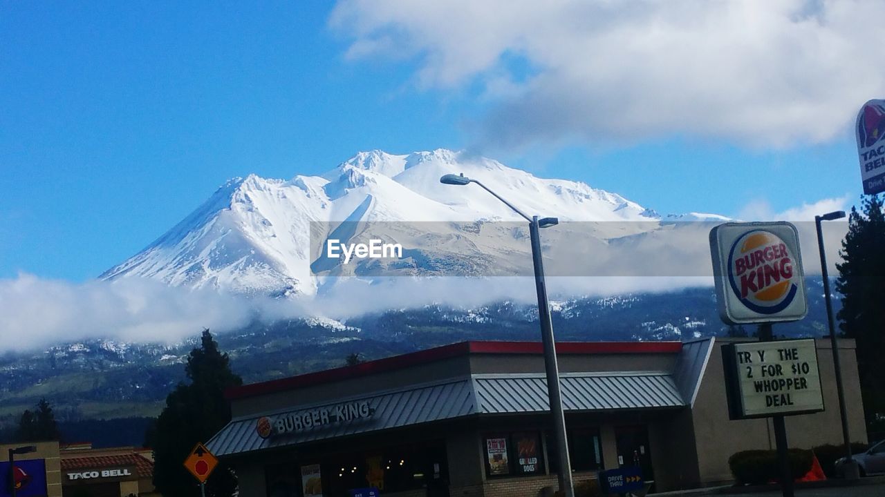 LOW ANGLE VIEW OF ILLUMINATED SNOW COVERED MOUNTAIN AGAINST SKY