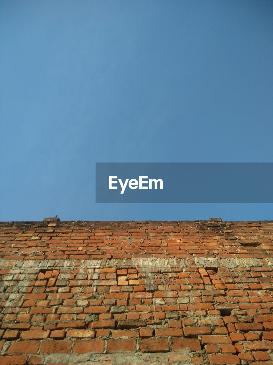 LOW ANGLE VIEW OF BRICK WALL AGAINST SKY