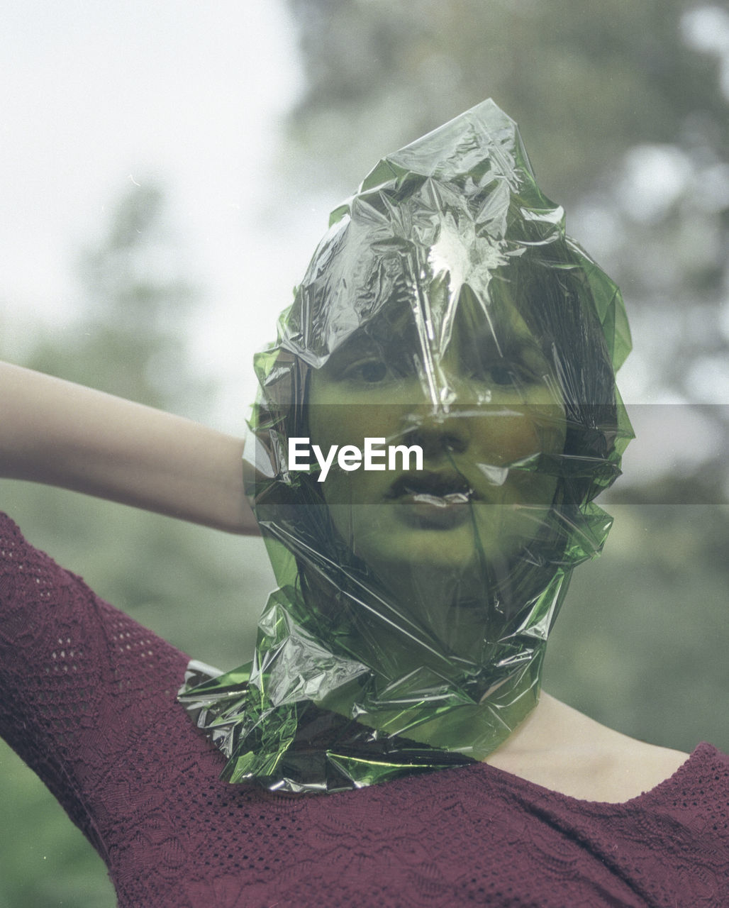 Close-up portrait of woman with plastic wrapped on face