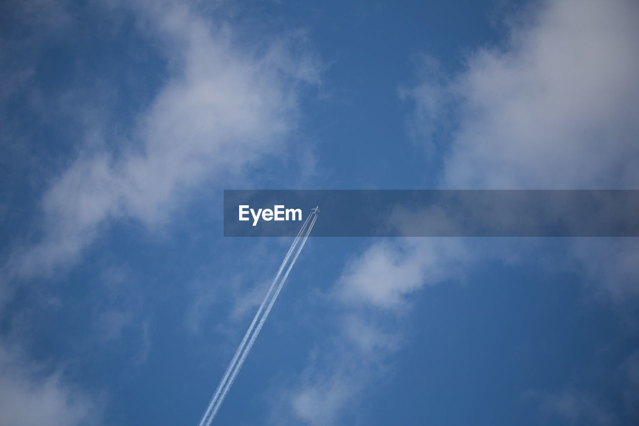 Low angle view of airplane against blue sky