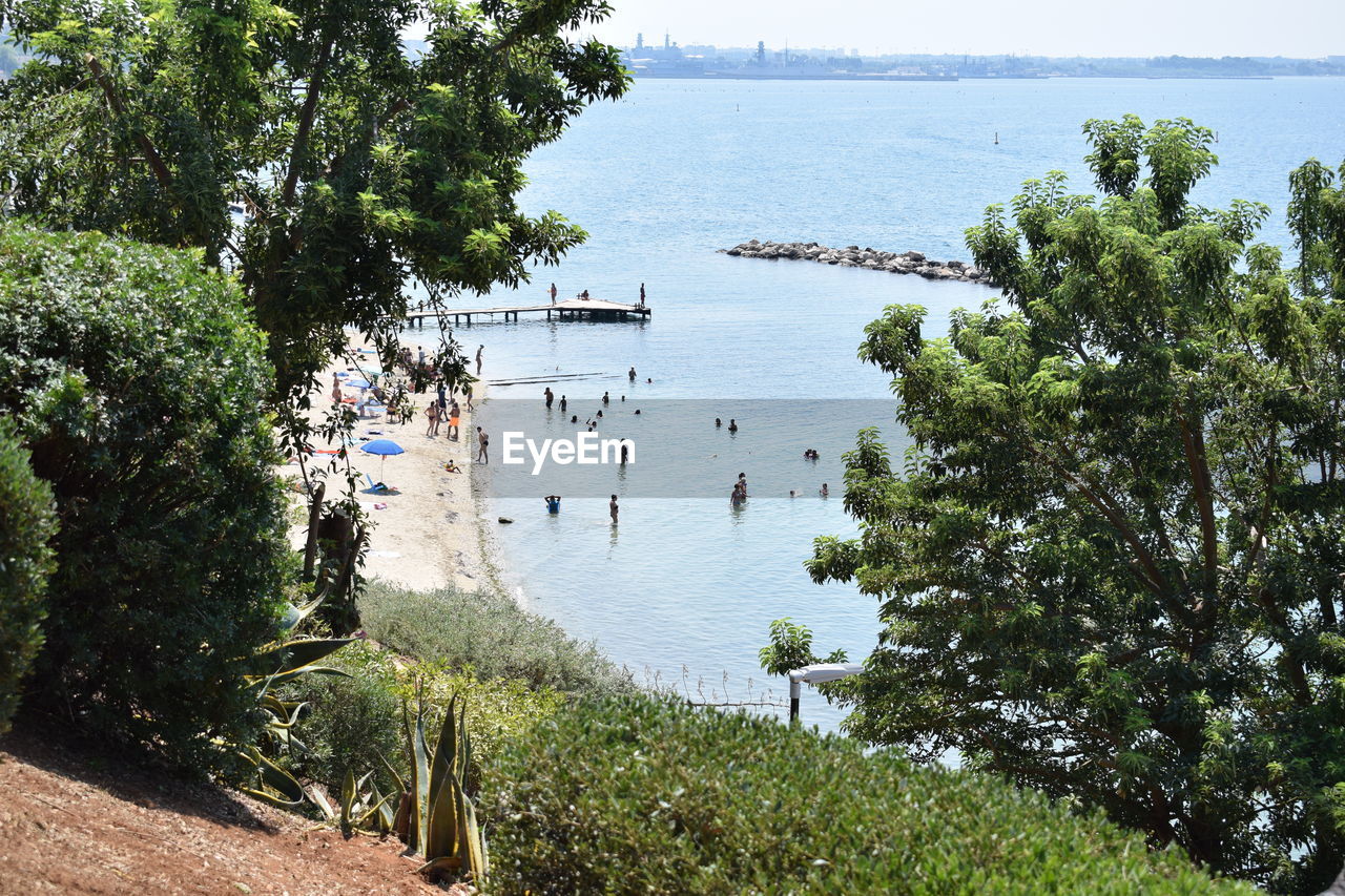 HIGH ANGLE VIEW OF PEOPLE ON BEACH AGAINST SEA