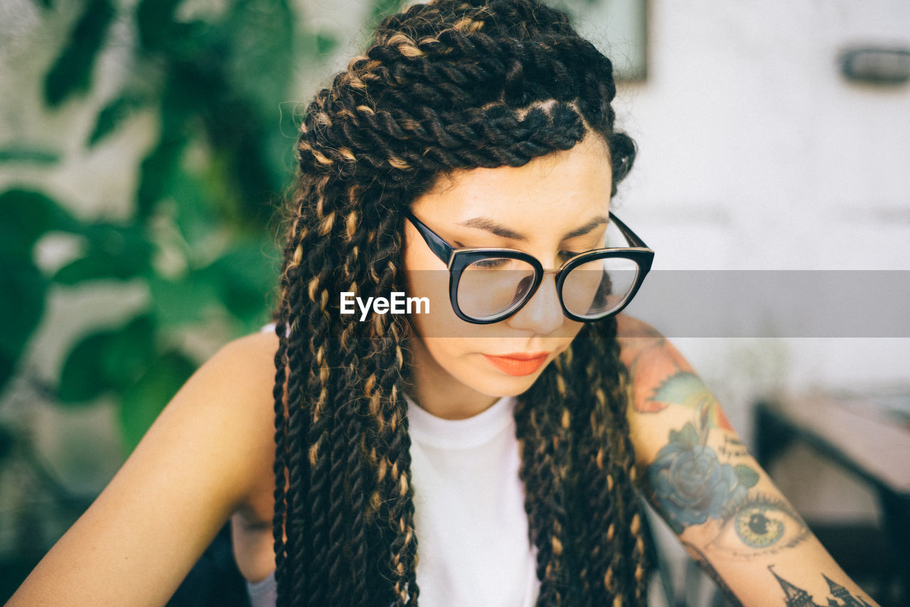 Young woman looking down while wearing eyeglasses