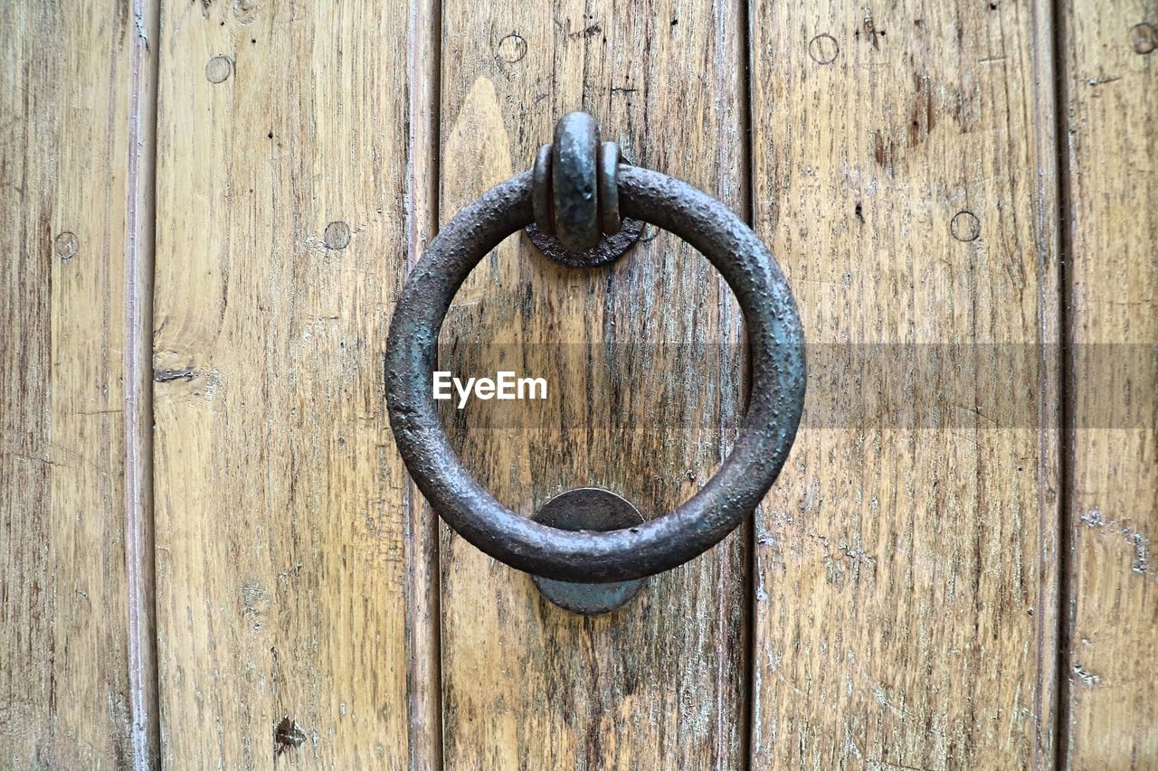 CLOSE-UP OF OLD WOODEN DOOR KNOCKER ON WOOD