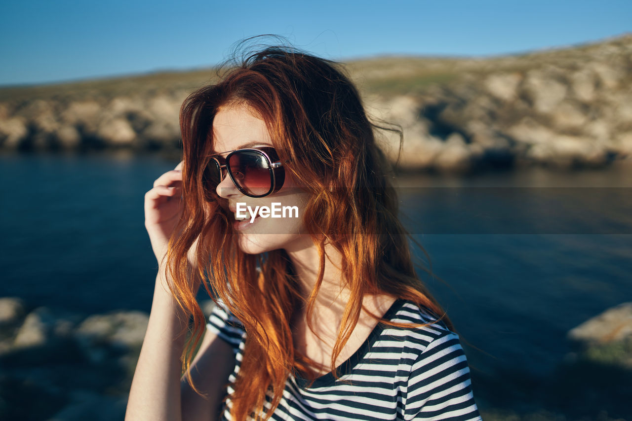 PORTRAIT OF BEAUTIFUL YOUNG WOMAN WITH SUNGLASSES