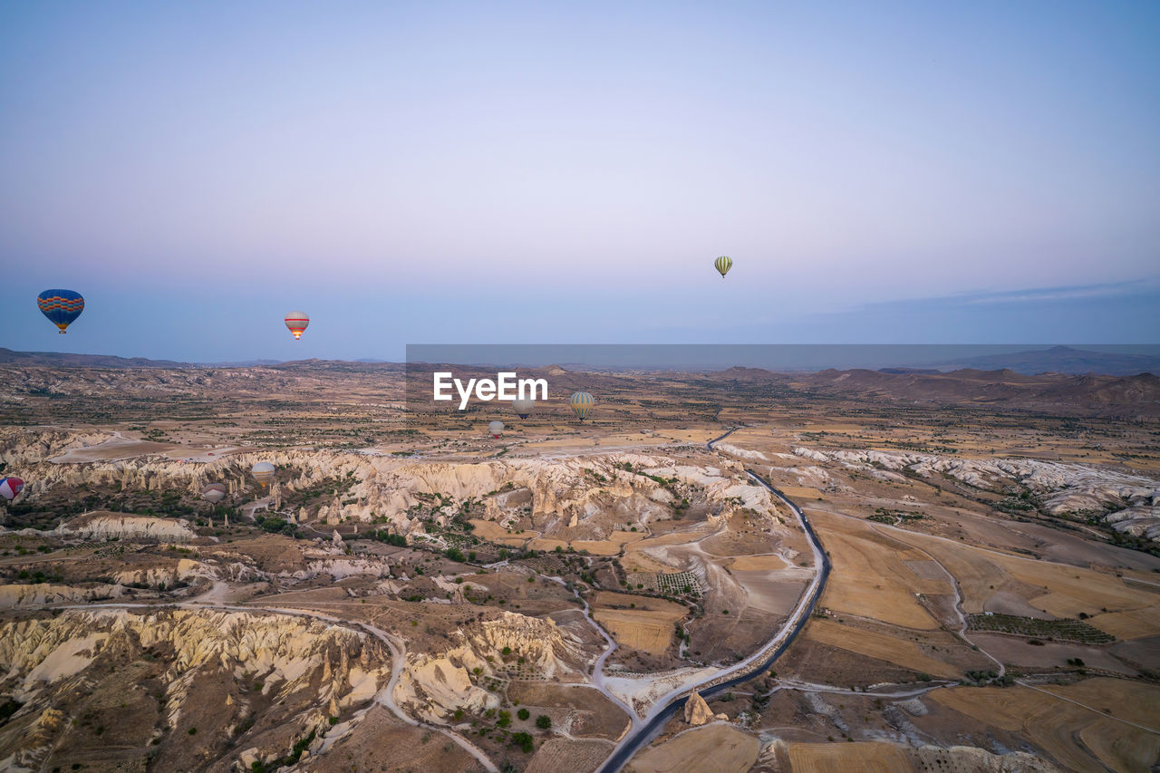 AERIAL VIEW OF HOT AIR BALLOON FLYING OVER LANDSCAPE