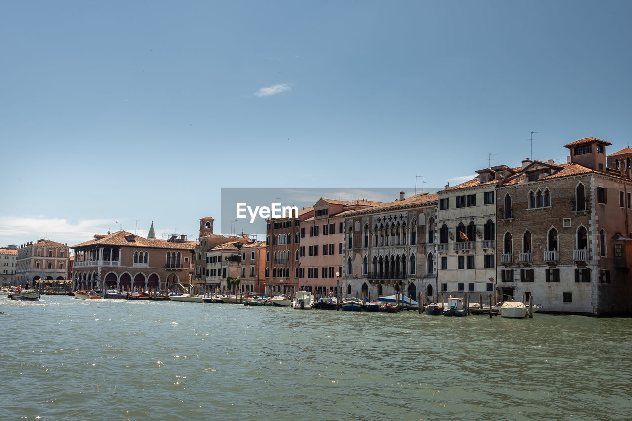 BUILDINGS BY SEA AGAINST SKY IN CITY