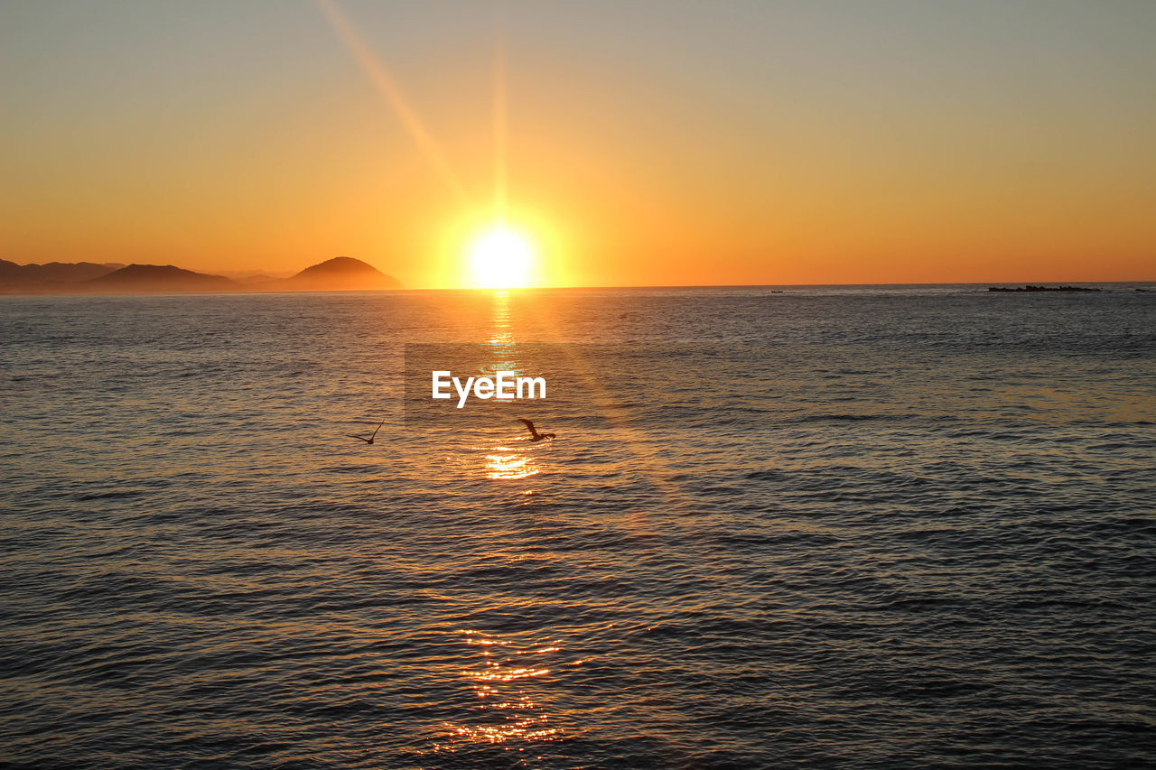 Scenic view of sea against orange sky