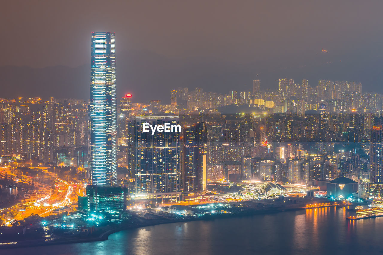 Illuminated buildings at victoria harbour in city during night