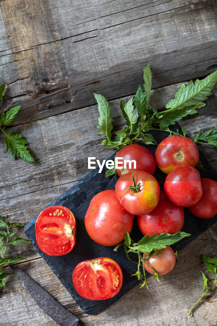 Organic healthy raw ripe pink tomatoes on a kitchen wooden table. 