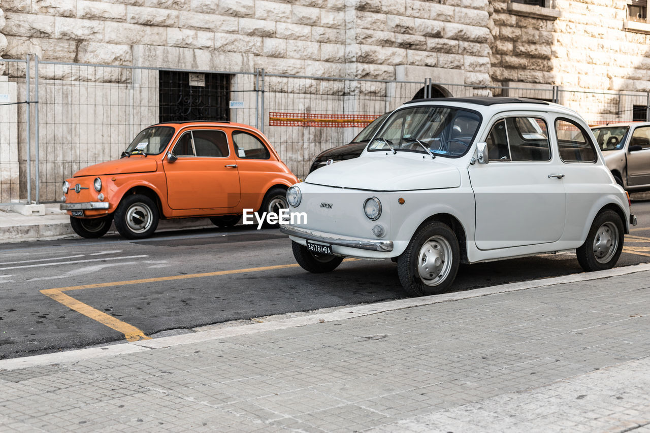 VINTAGE CAR PARKED ON COBBLESTONE