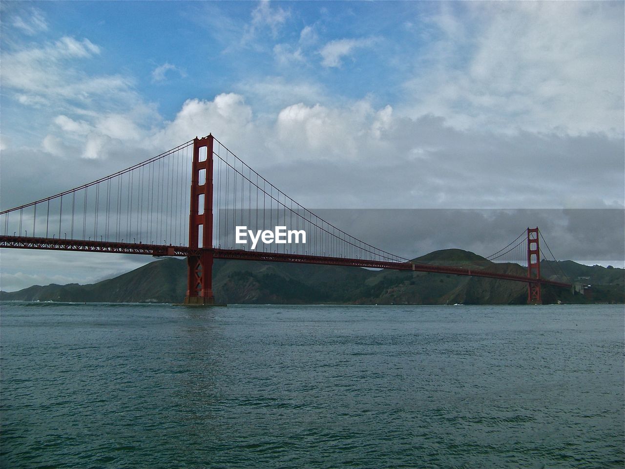 View of suspension bridge against cloudy sky