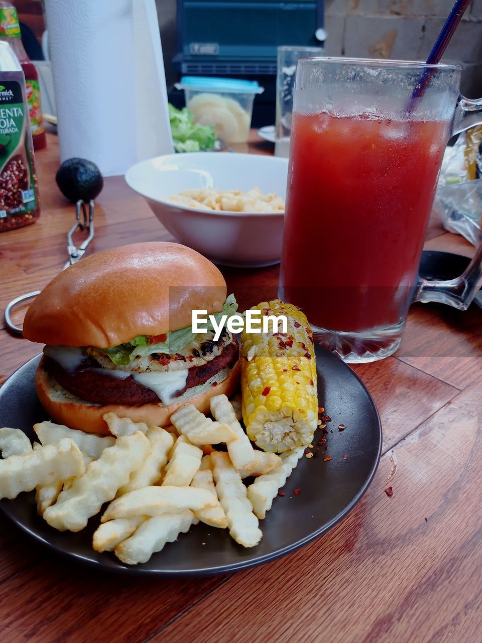 HIGH ANGLE VIEW OF BURGER AND VEGETABLES ON TABLE