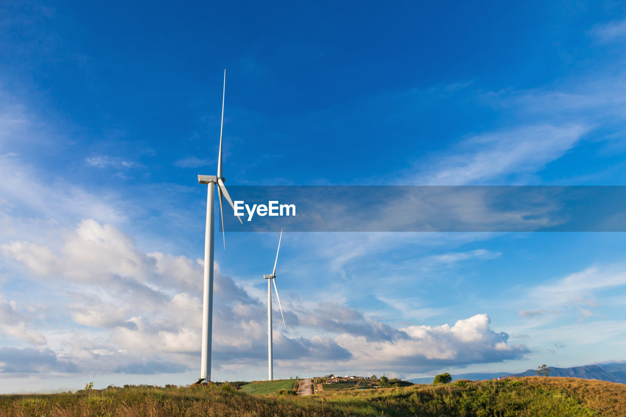 LOW ANGLE VIEW OF WIND TURBINE ON FIELD AGAINST SKY