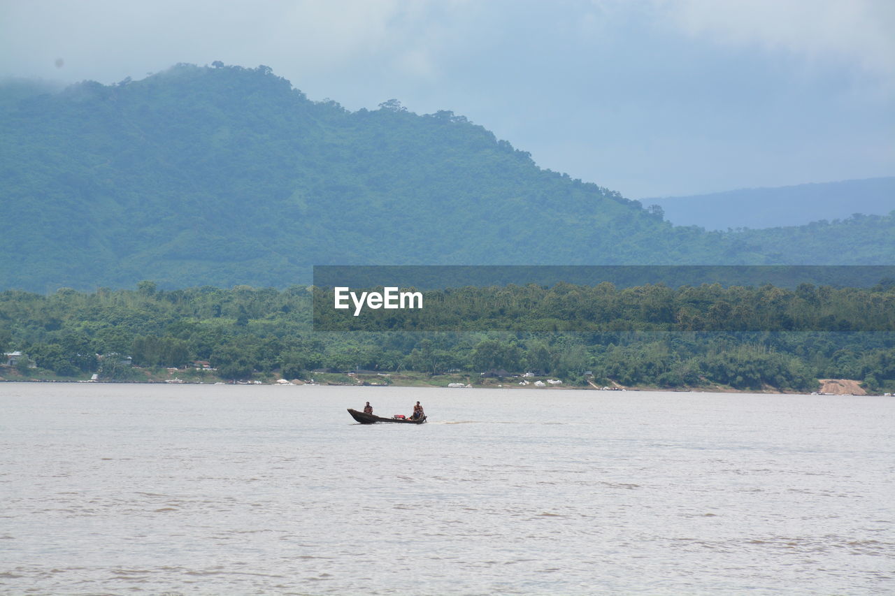 MAN IN SEA AGAINST MOUNTAINS