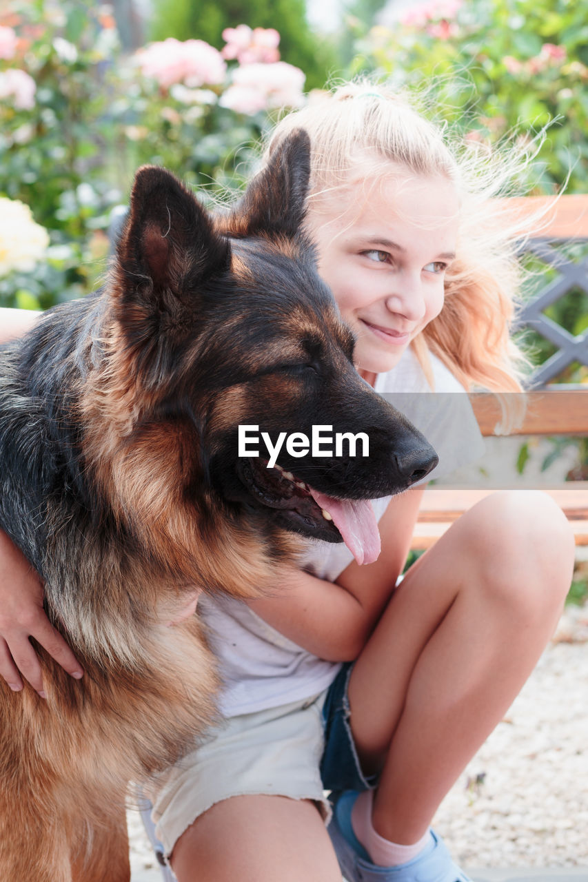 Girl with dog sitting outdoors