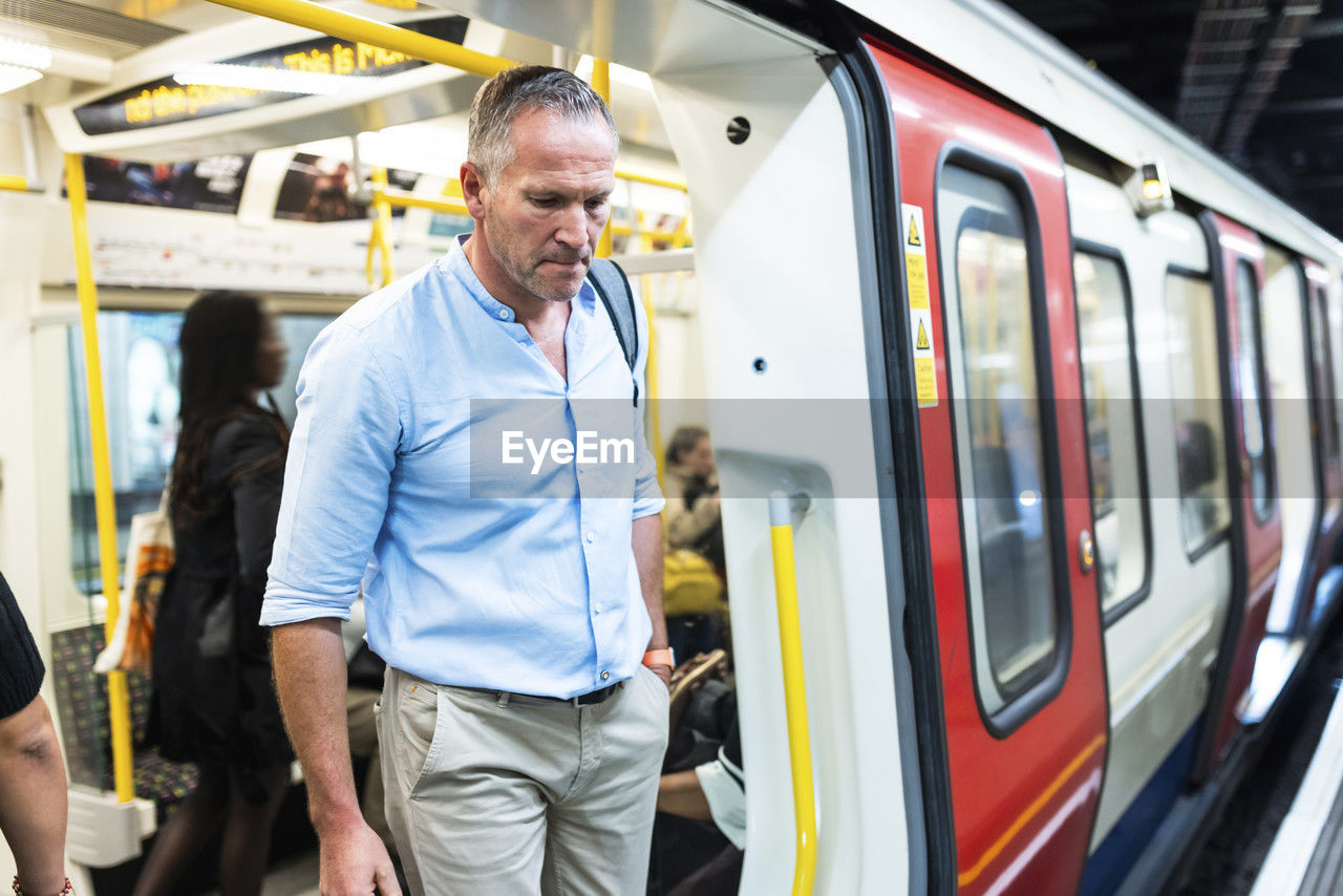 Businessman disembarking from train at subway station