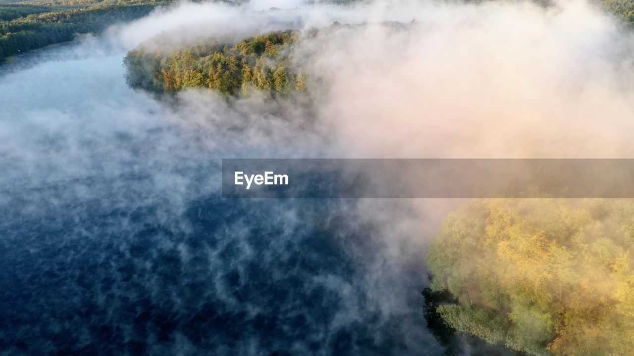 Scenic view of lake with fog in the morning 