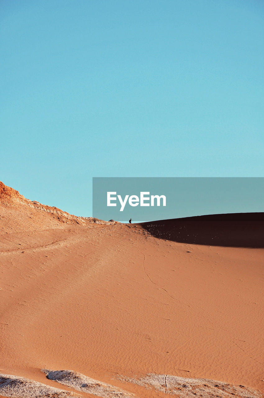 View of desert against clear blue sky