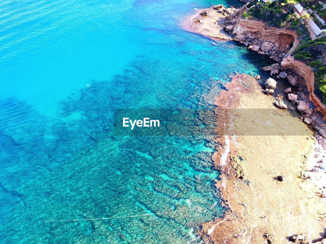 HIGH ANGLE VIEW OF ROCKS ON SEA SHORE