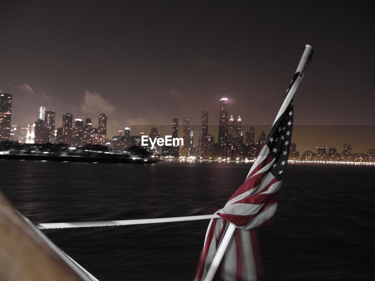 American flag against illuminated skyline