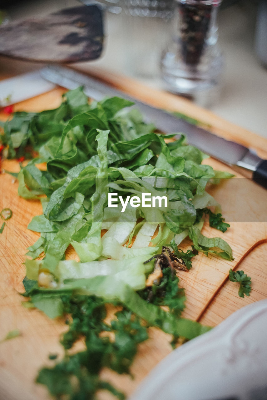 CLOSE-UP OF CHOPPED VEGETABLES ON CUTTING BOARD