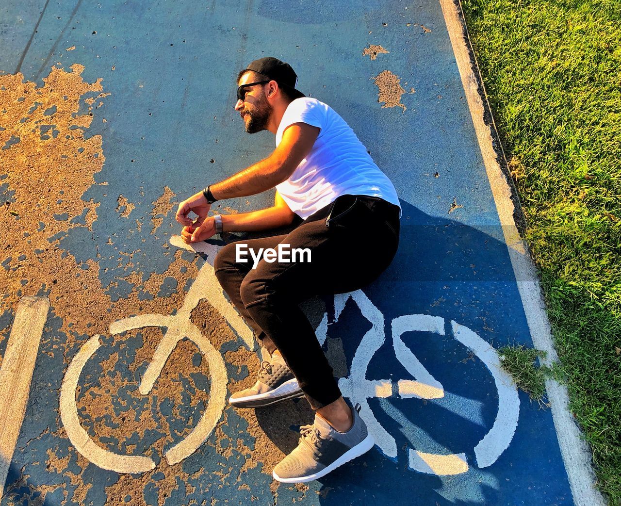 High angle view of man lying on road with bicycle symbol