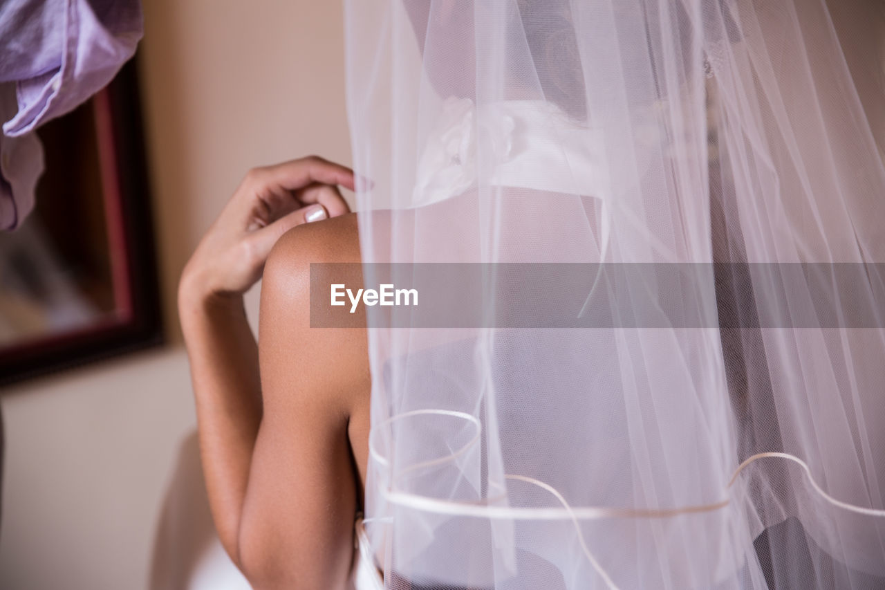 Midsection of bride wearing veil