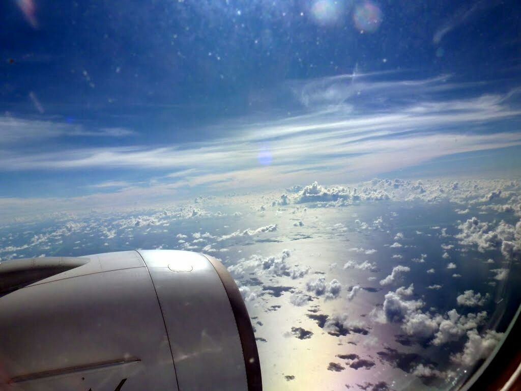 LOW ANGLE VIEW OF AIRPLANE WING OVER LANDSCAPE