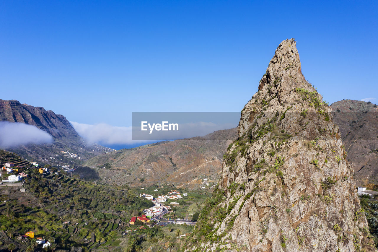 Spain, hermigua, drone view of roques de san pedro and small town in garajonay national park