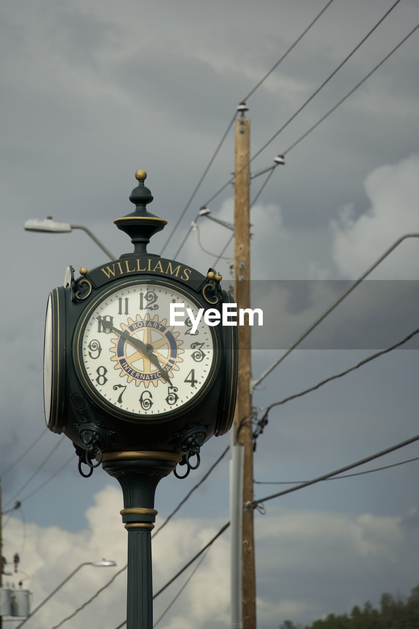 clock, time, sky, cloud, architecture, clock face, lighting, no people, tower, street light, low angle view, nature, built structure, clock tower, minute hand, technology, light fixture, building exterior, day, electricity, street, cable, outdoors, city