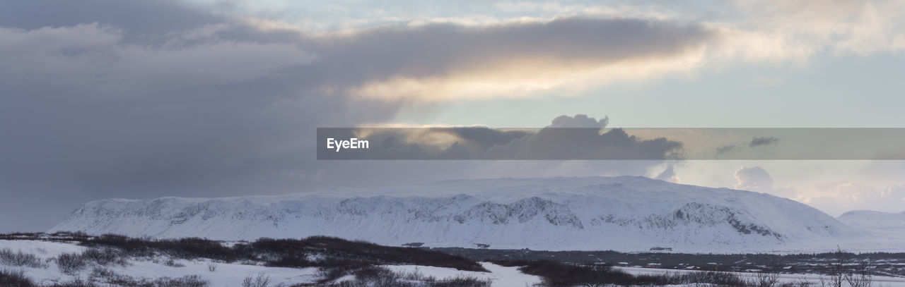 Scenic view of snow covered mountains against sky