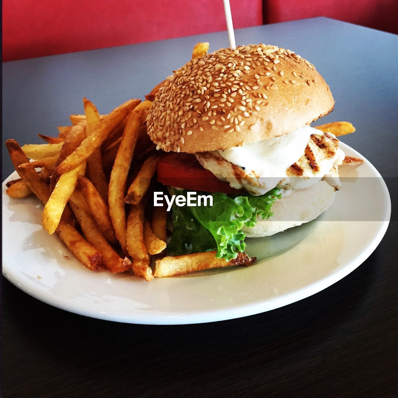 High angle view of burger by french fries served in plate on table