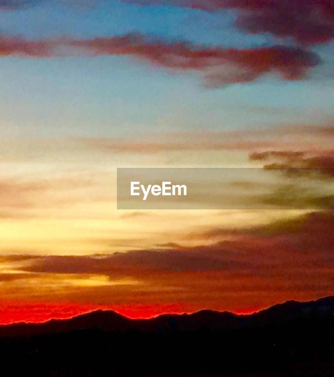 Silhouette of mountain against dramatic sky