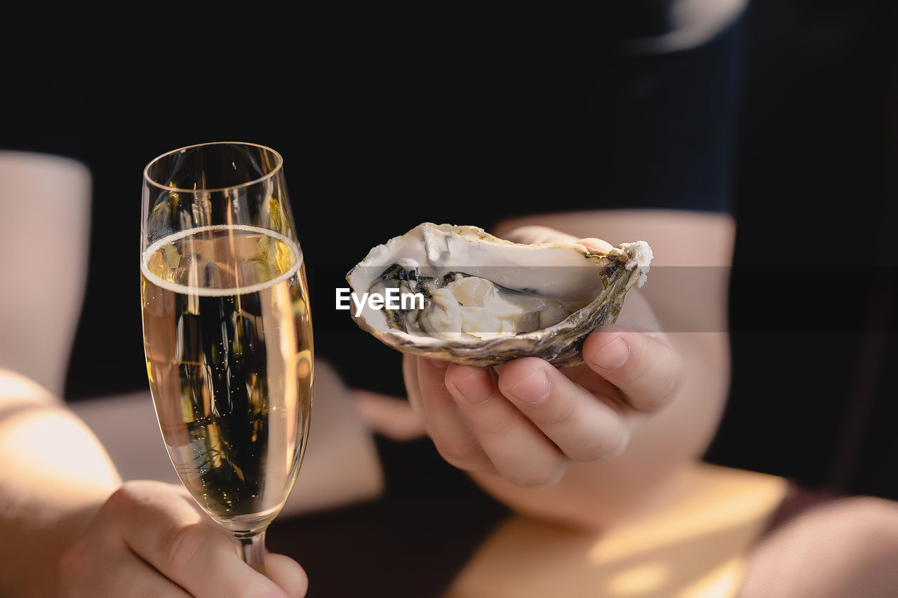 An oyster and a glass of champagne in the hand