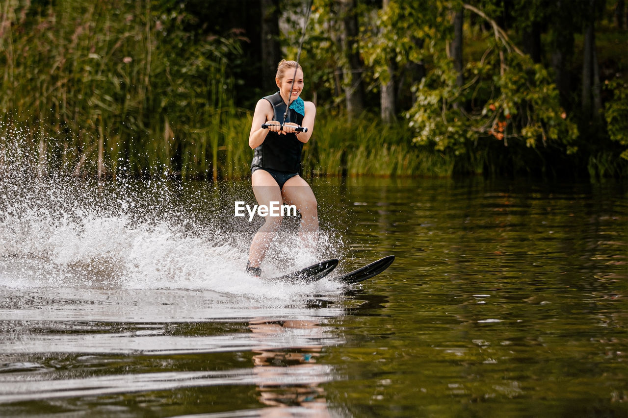 Full length of man splashing water in lake