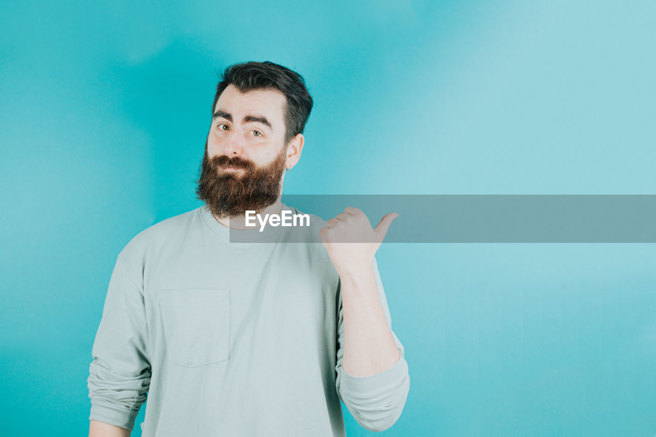 low angle view of man with arms crossed against blue background