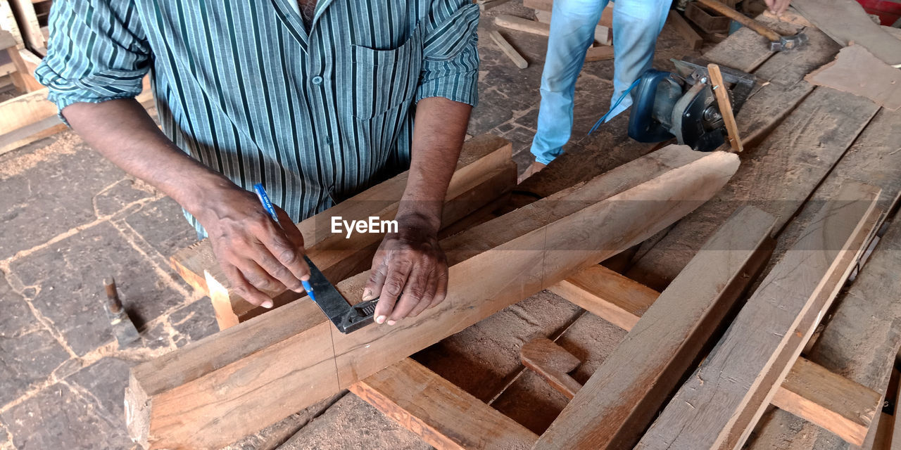 Midsection of carpenter working in workshop