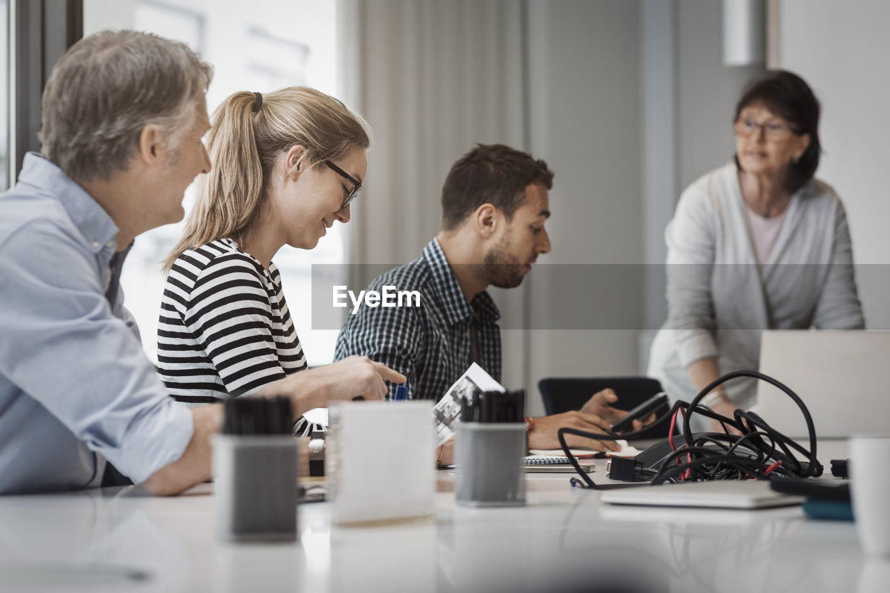 Senior businesswoman giving presentation to colleagues in board room