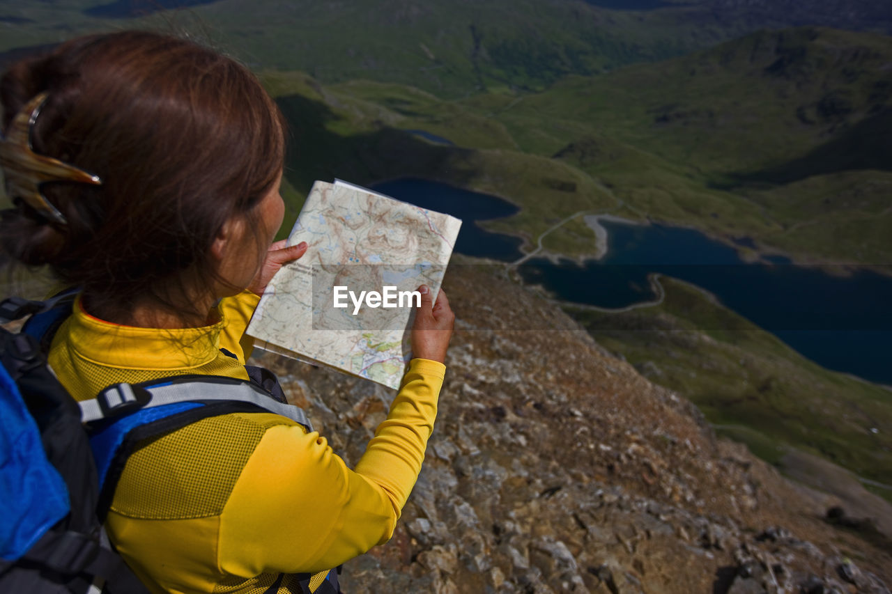 Woman reading a map on snowdonia mountain