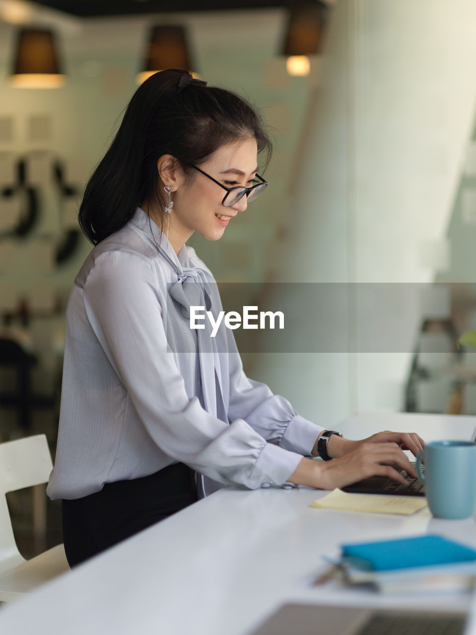 Side view of businesswoman working on computer in office