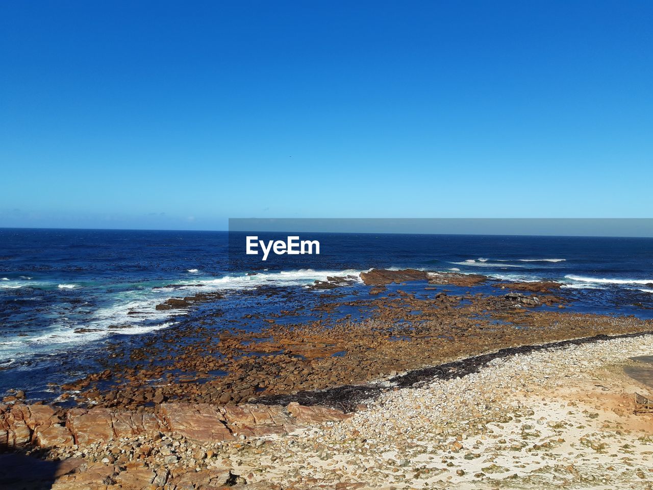 Scenic view of sea against clear blue sky