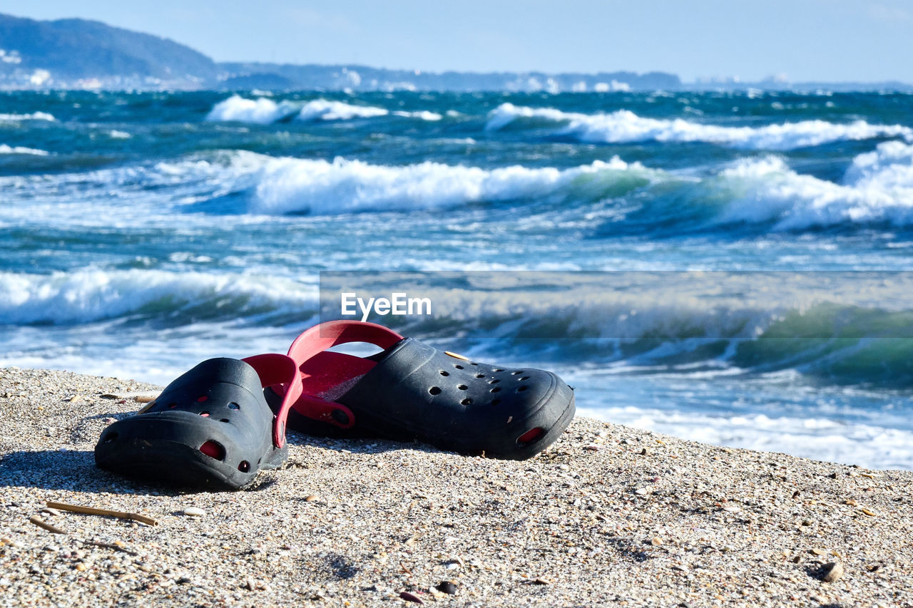 Scenic view of sea against sky with close up of sandal