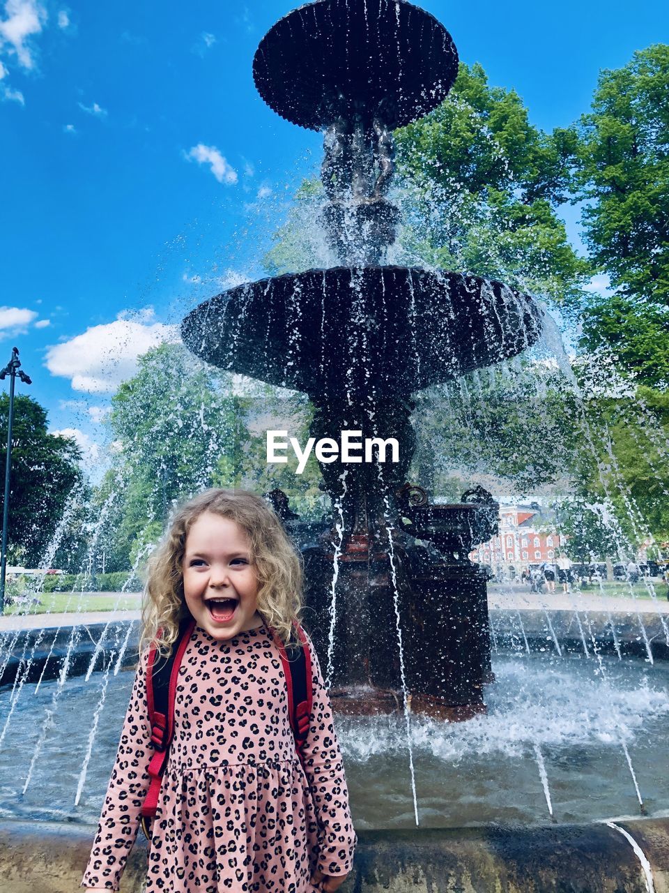 Cute girl splashing water fountain