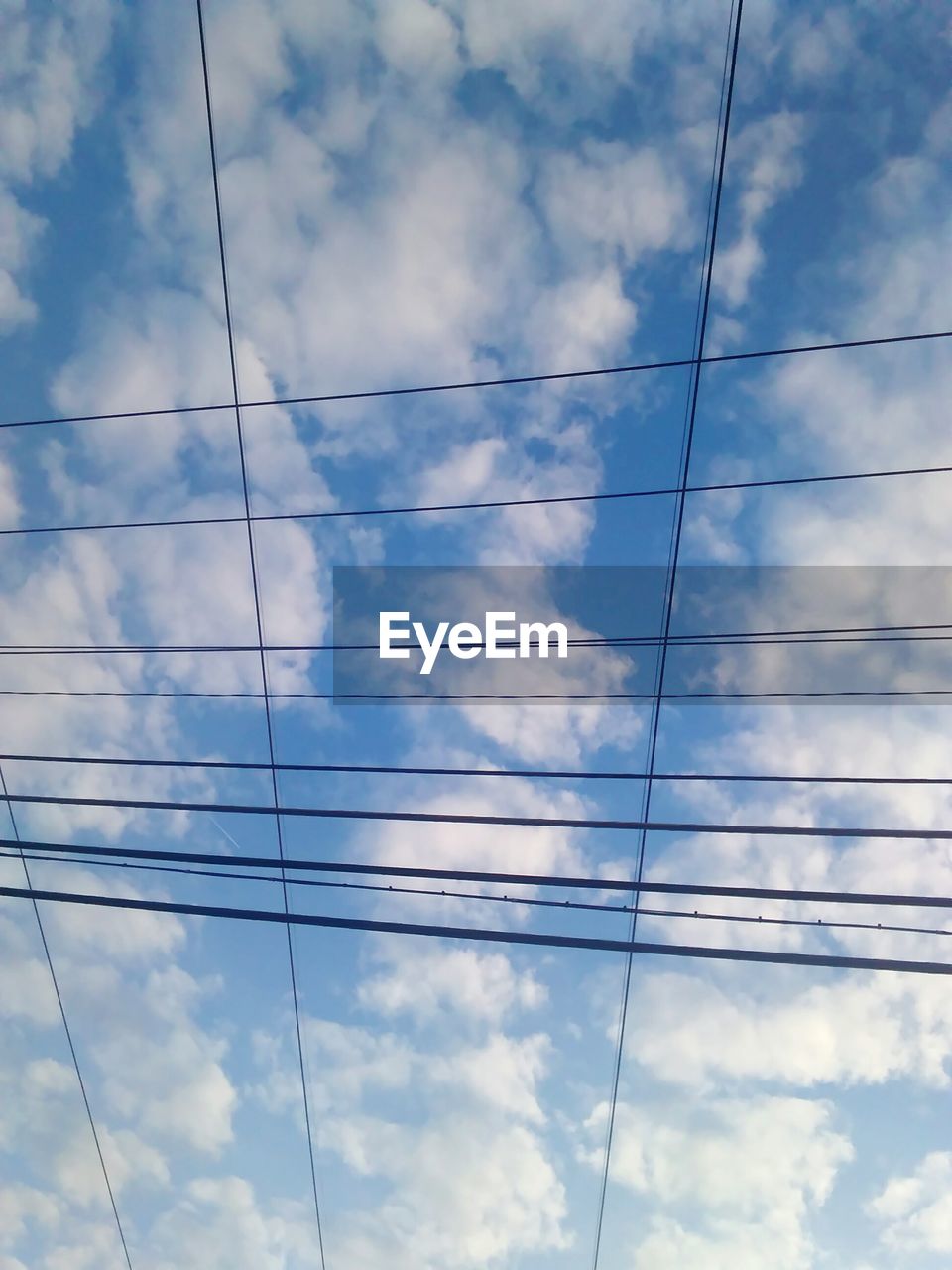 LOW ANGLE VIEW OF POWER CABLES AGAINST SKY