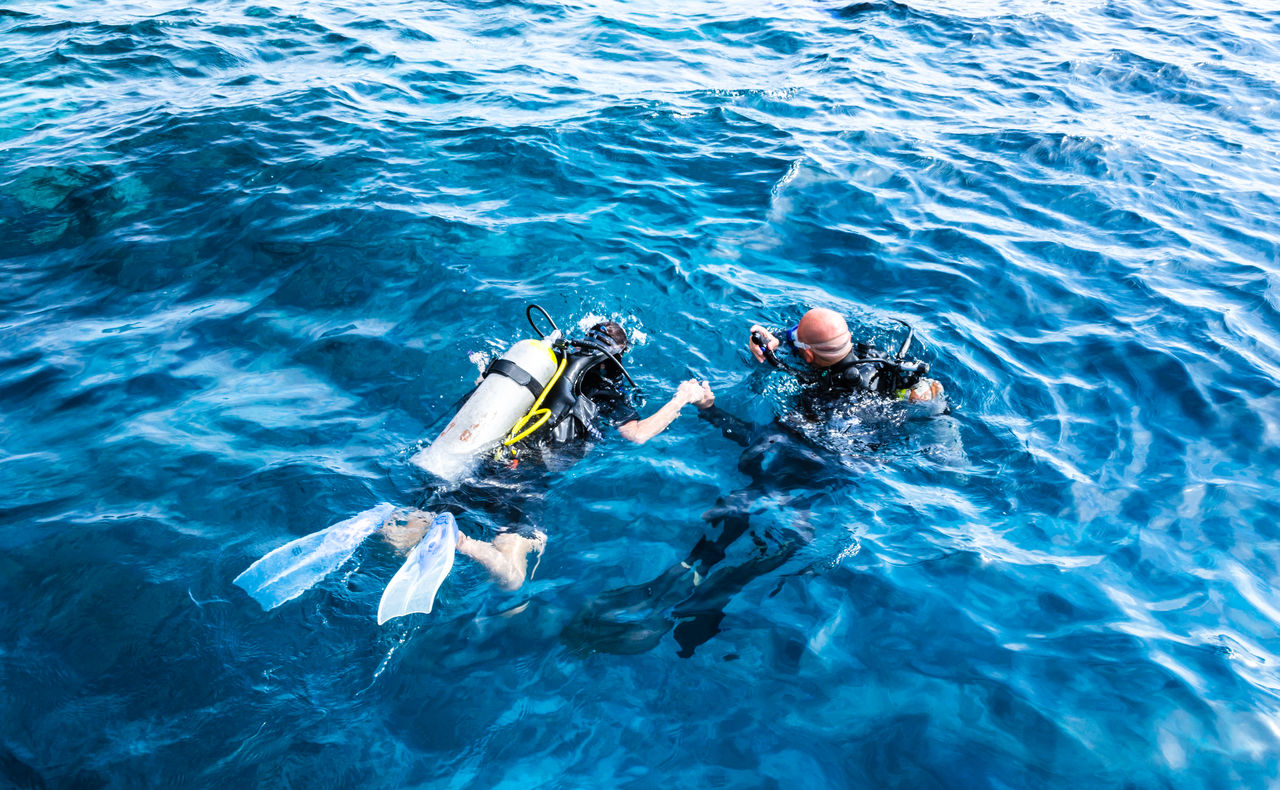 HIGH ANGLE VIEW OF PEOPLE IN SEA