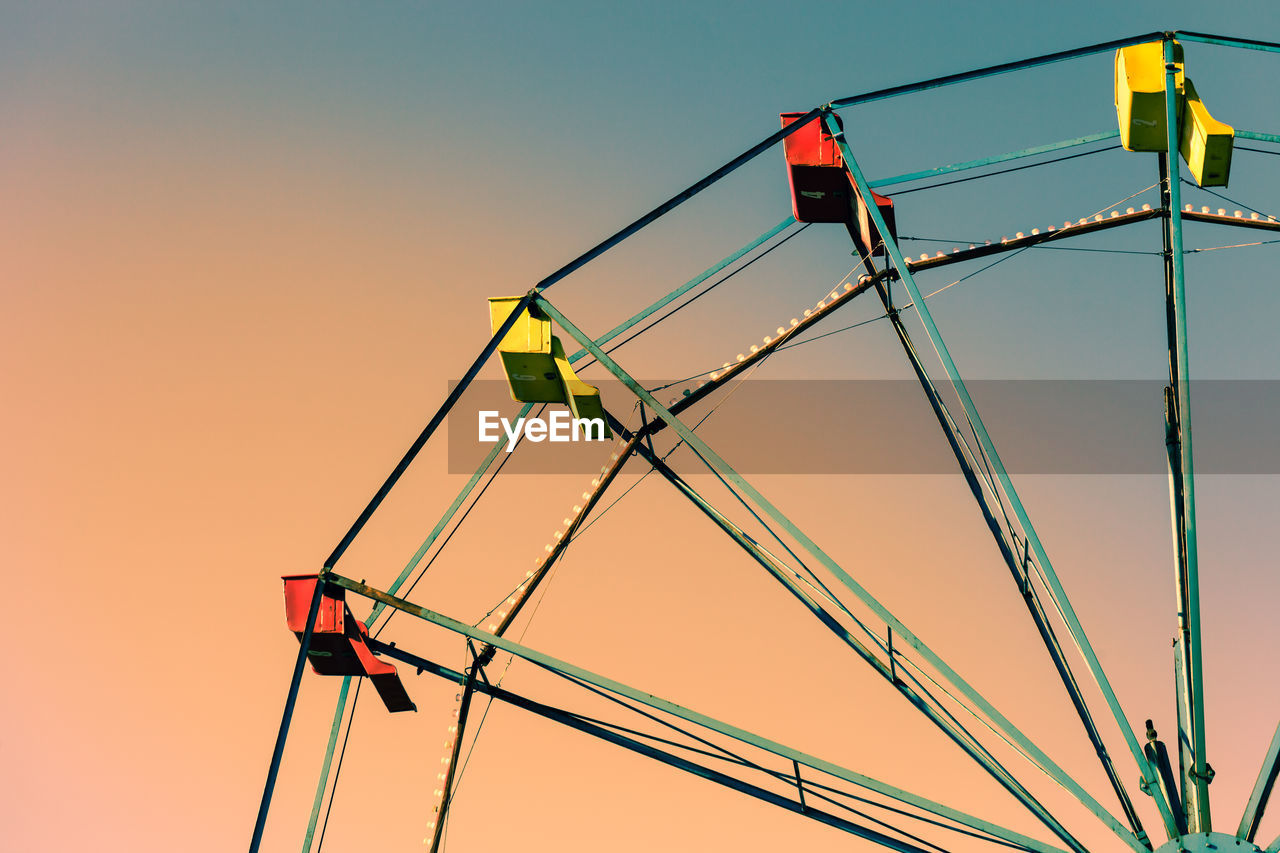 Low angle view of illuminated ferries wheel against clear sky