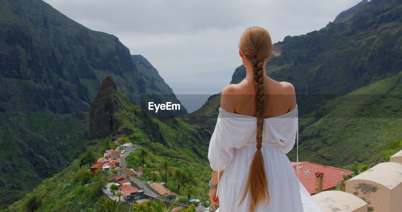 Masca gorge and village on tenerife island. woman standing on viewpoint. tropical nature. rear view.